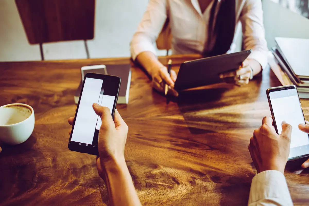 Midsection of woman using smart phone on table