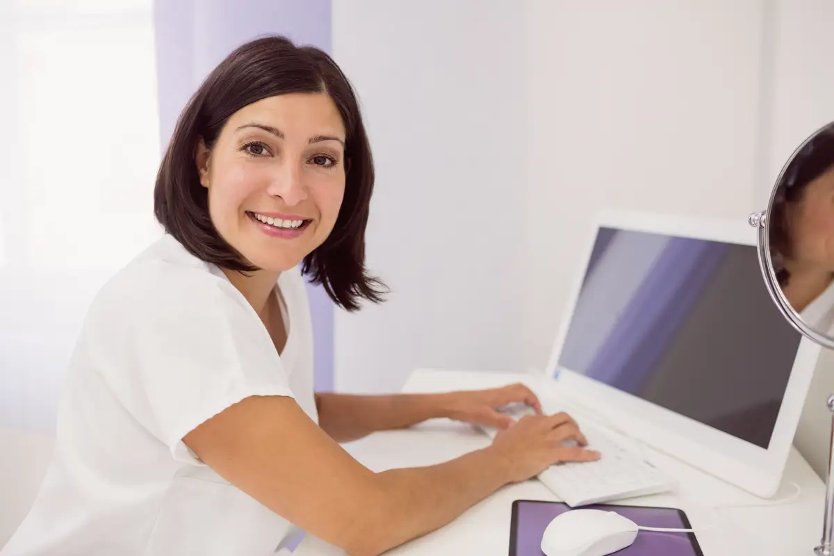 Smiling doctor using desktop pc