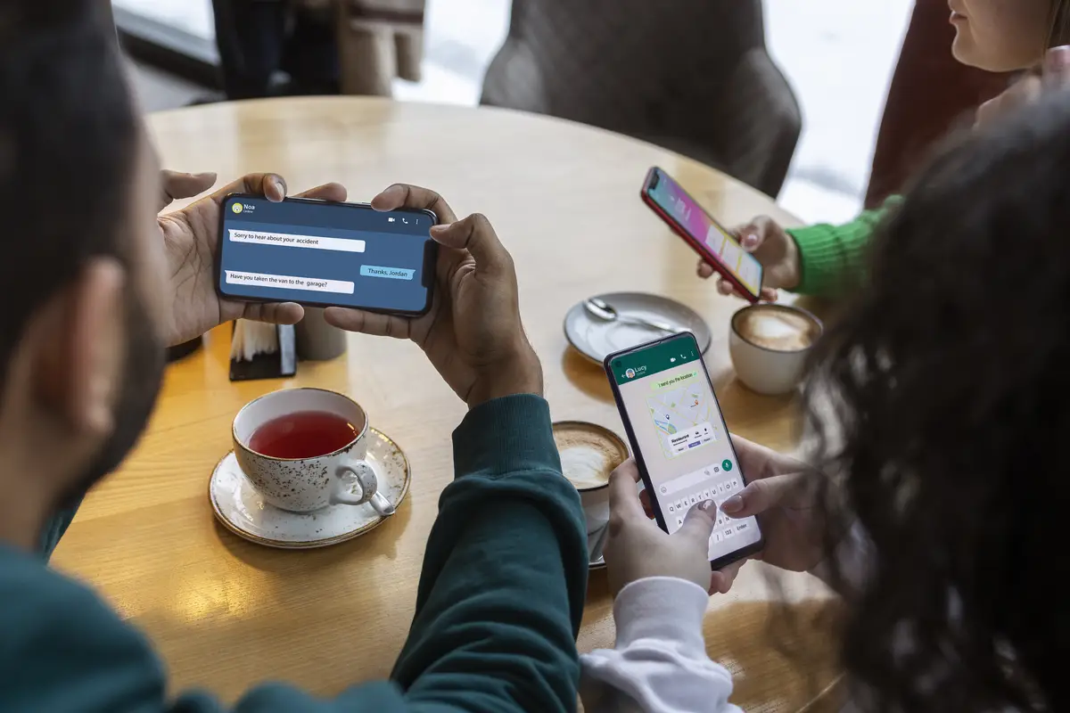 High angle friends holding smartphones