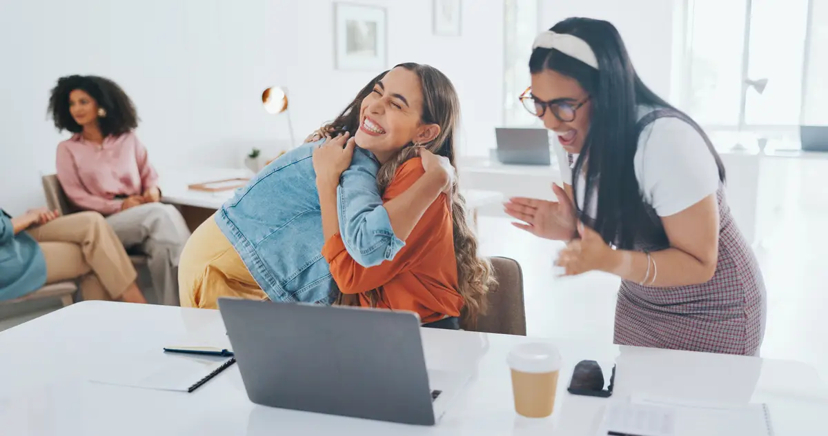Laptop success or women high five at work in celebration of digital marketing sales goals or kpi target Happy winner or excited employees hugging to celebrate bonus business growth or achievement