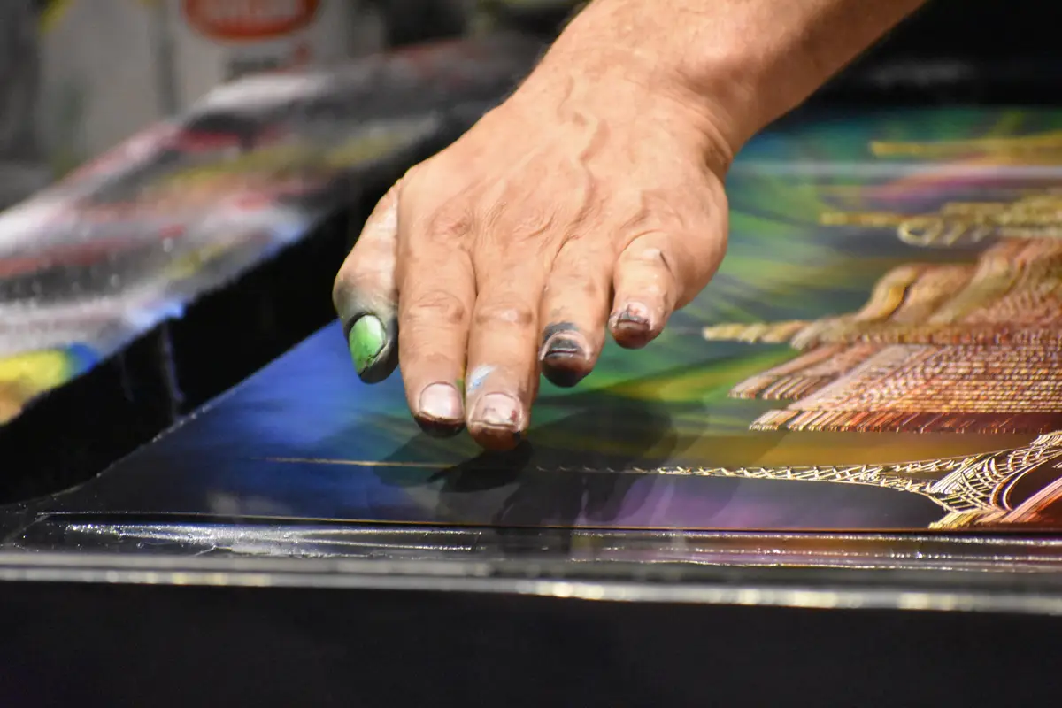 Close-up of messy human hand over paintings