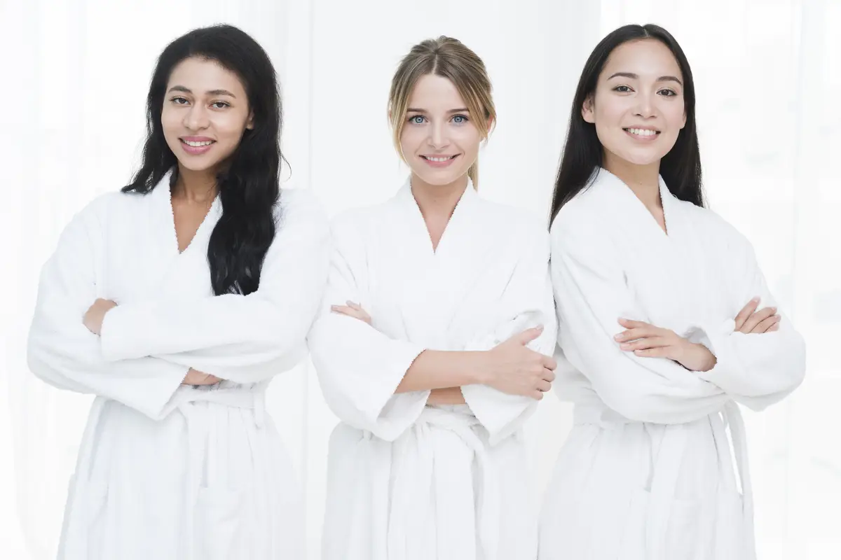 Friends posing with bathrobe in a spa
