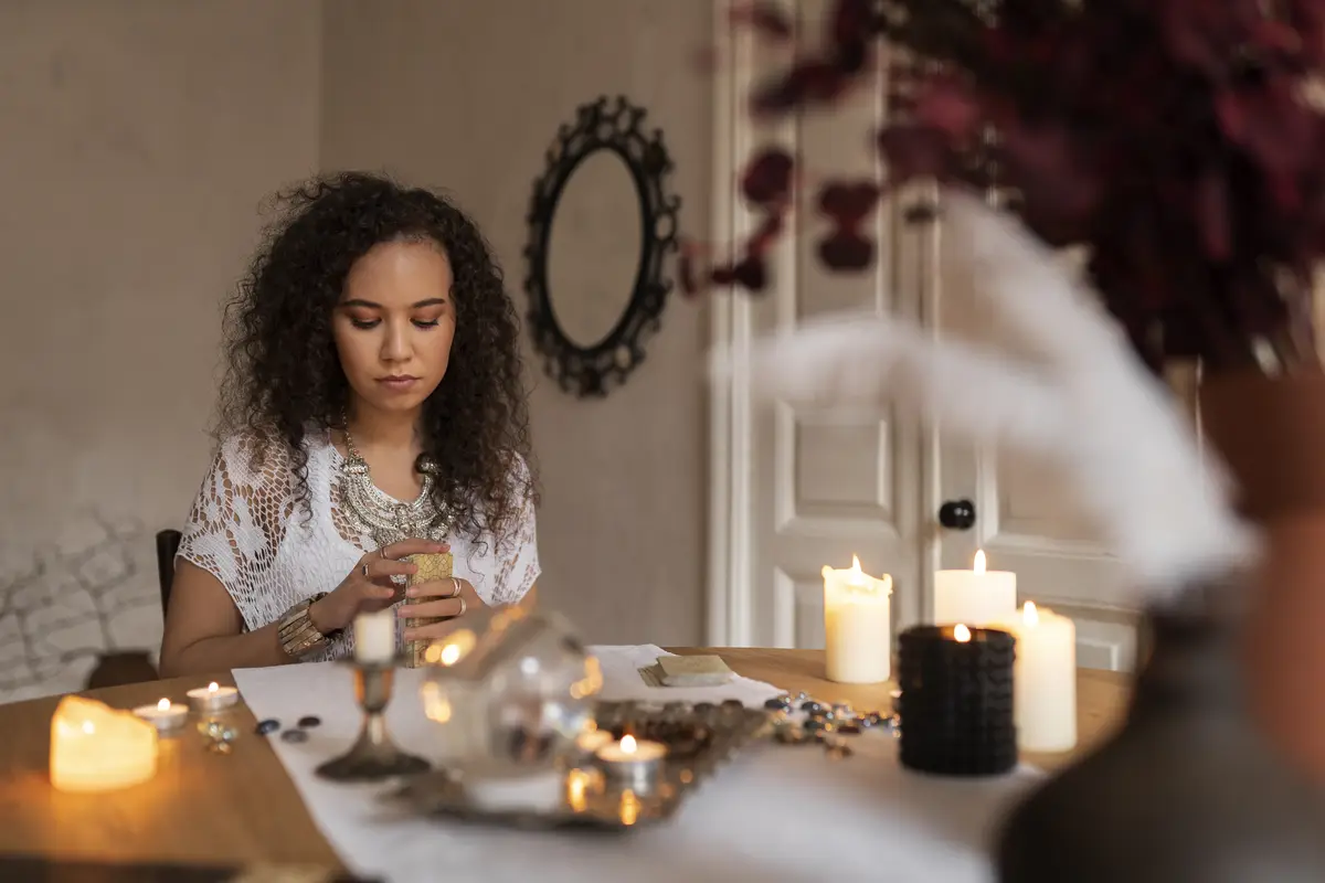 Medium shot woman reading tarot at home