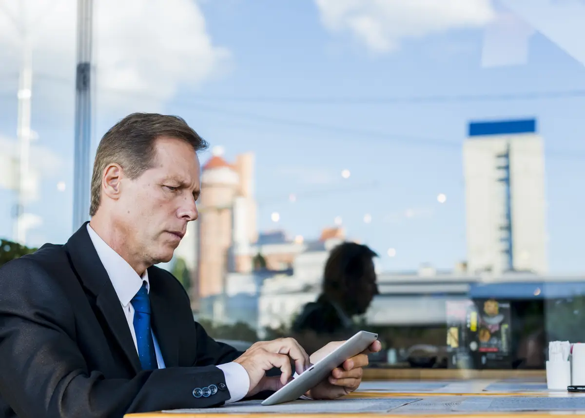 Serious businessman using digital tablet in restaurant