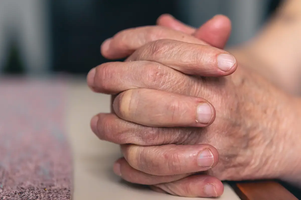 Hands of an old woman folded for prayer