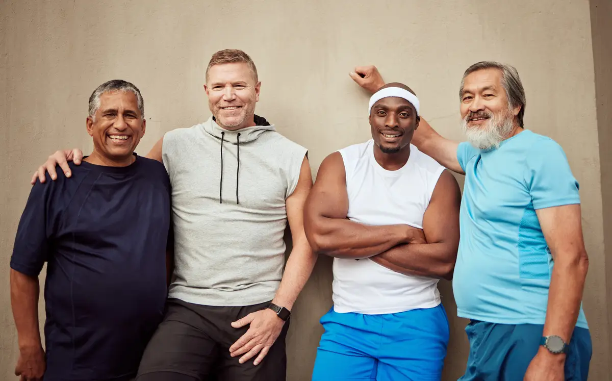 Happy men portrait and sports group on wall background in outdoor city Smile fitness and mature male friends with motivation for workout wellness support and exercise energy for healthy lifestyle