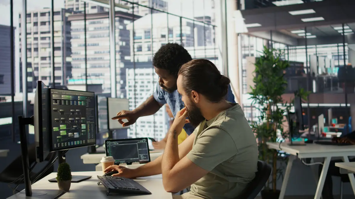 Team leader supervising IT staff member optimizing code