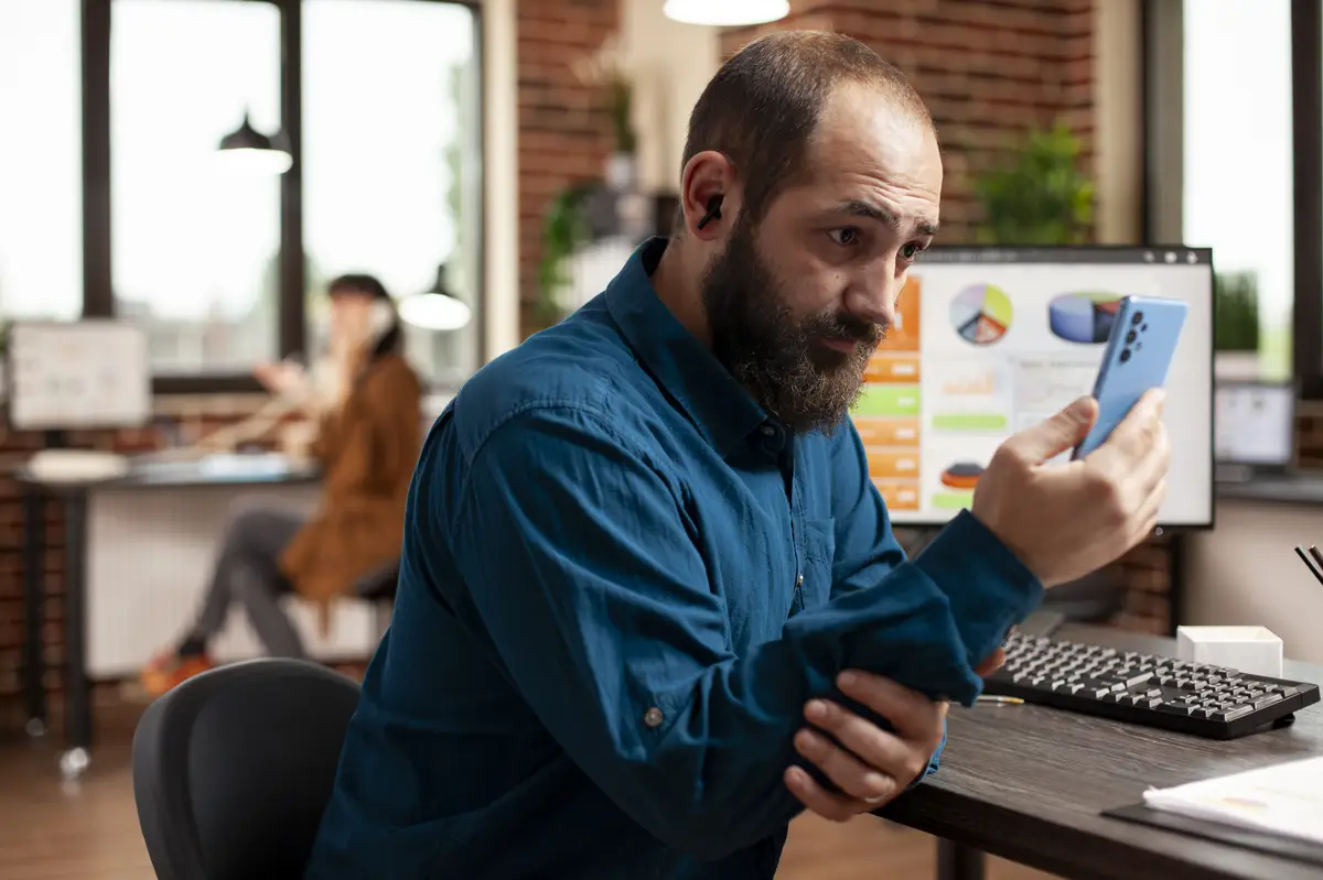 Young man checking social media at work