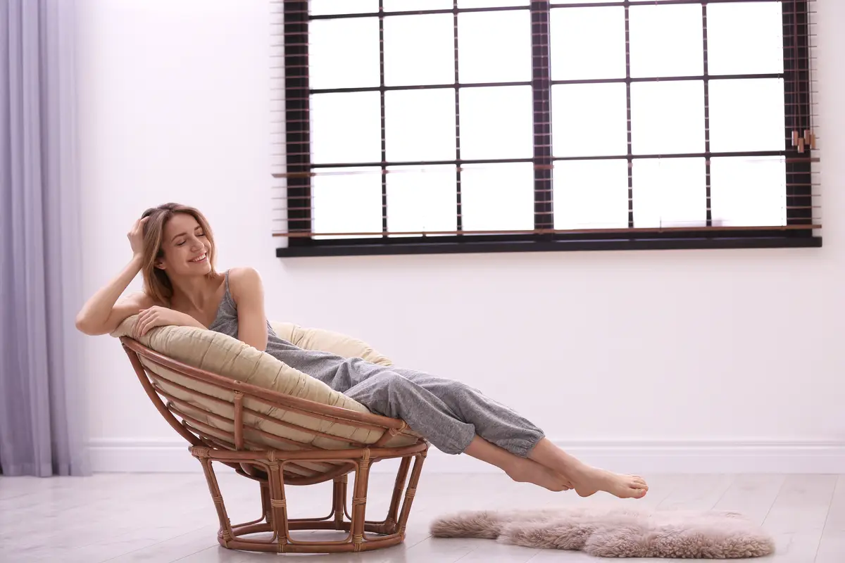 Young woman relaxing near window with blinds at home Space for text