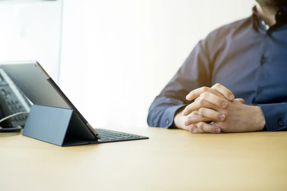 Businessman's hand with laptop over wooden desk