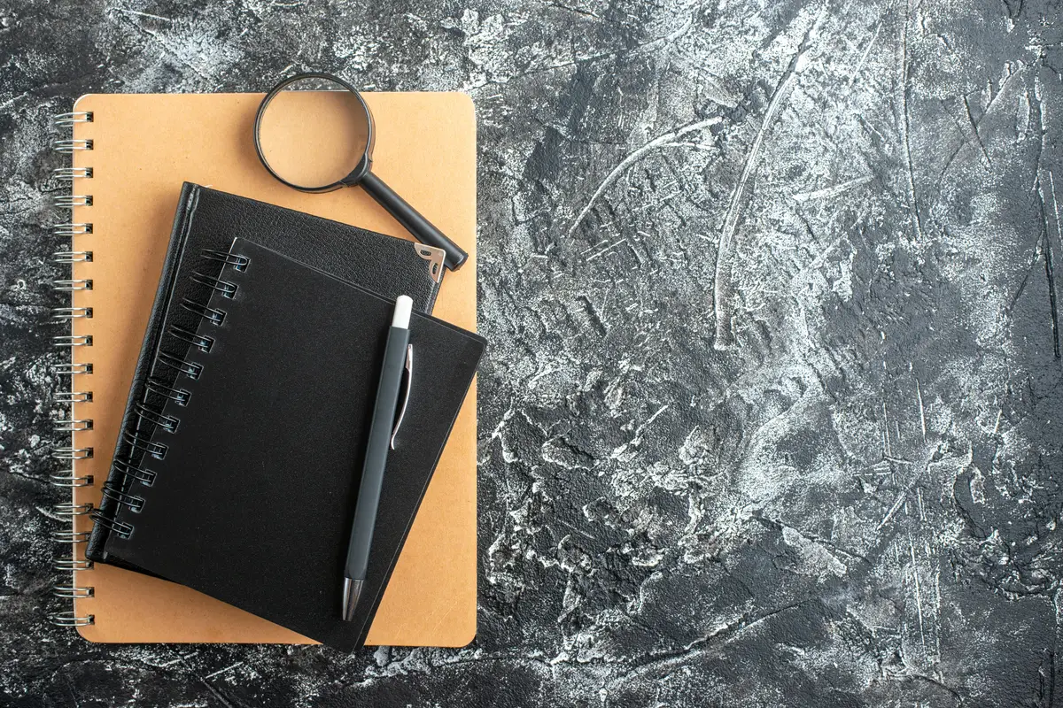 Top view of school supplies on dark surface