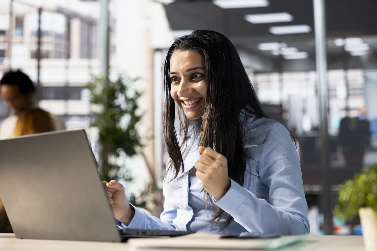 Smiling CEO in the office celebrates a major business milestone