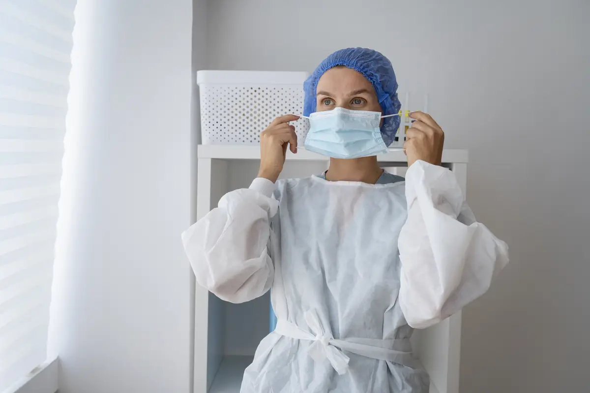 Contágio e prevenção da tuberculose pulmonar em hospitais 2 Front view woman putting on face mask