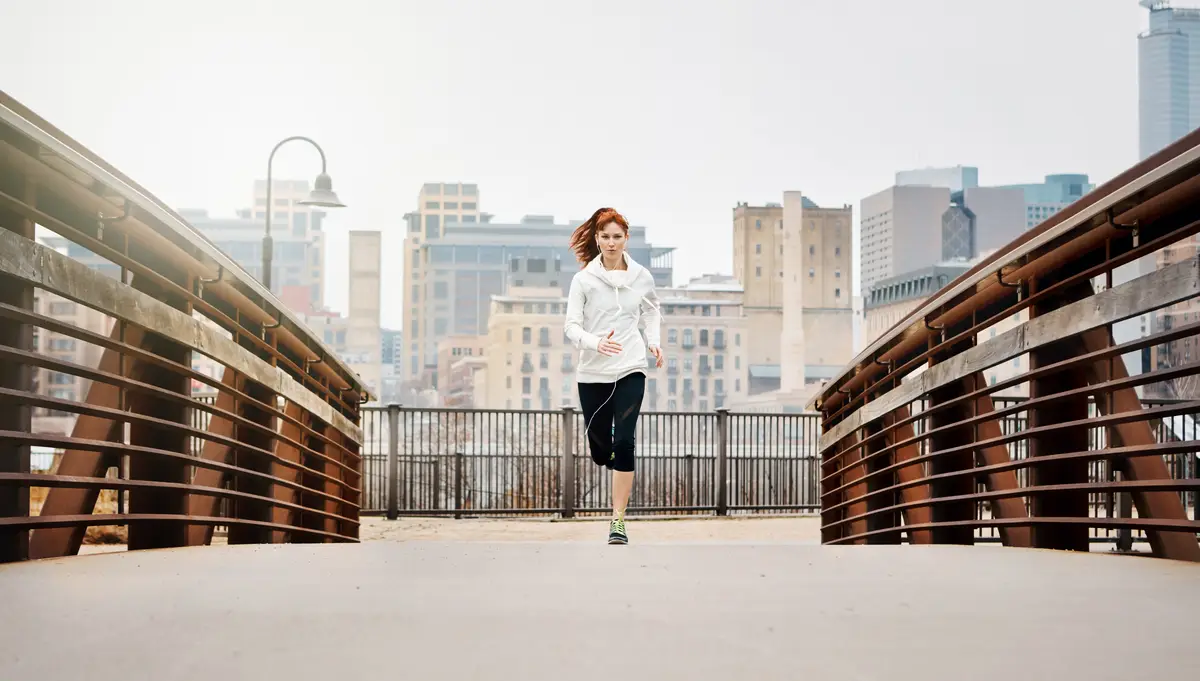 Endurance woman and running by bridge in city race and speed with fitness exercise Germany Training female runner and preparation for marathon challenge and healthy living with workout outdoor