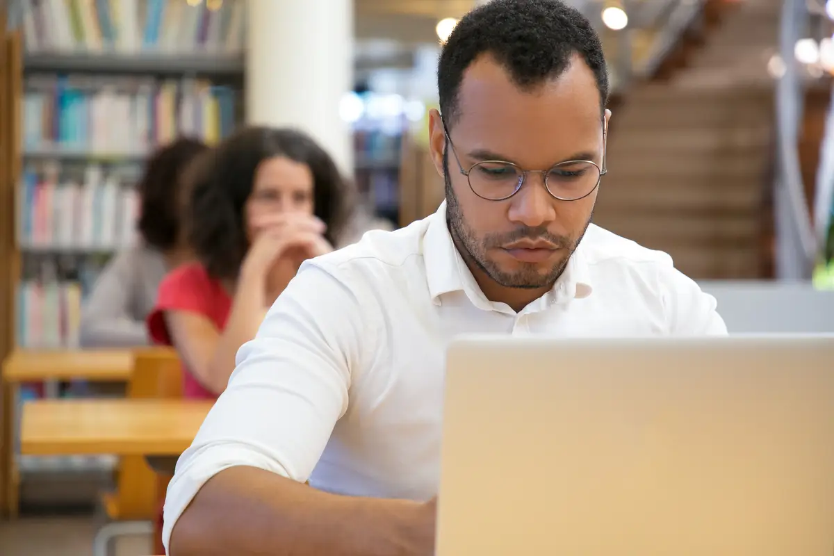 Front view of concentrated man typing on laptop