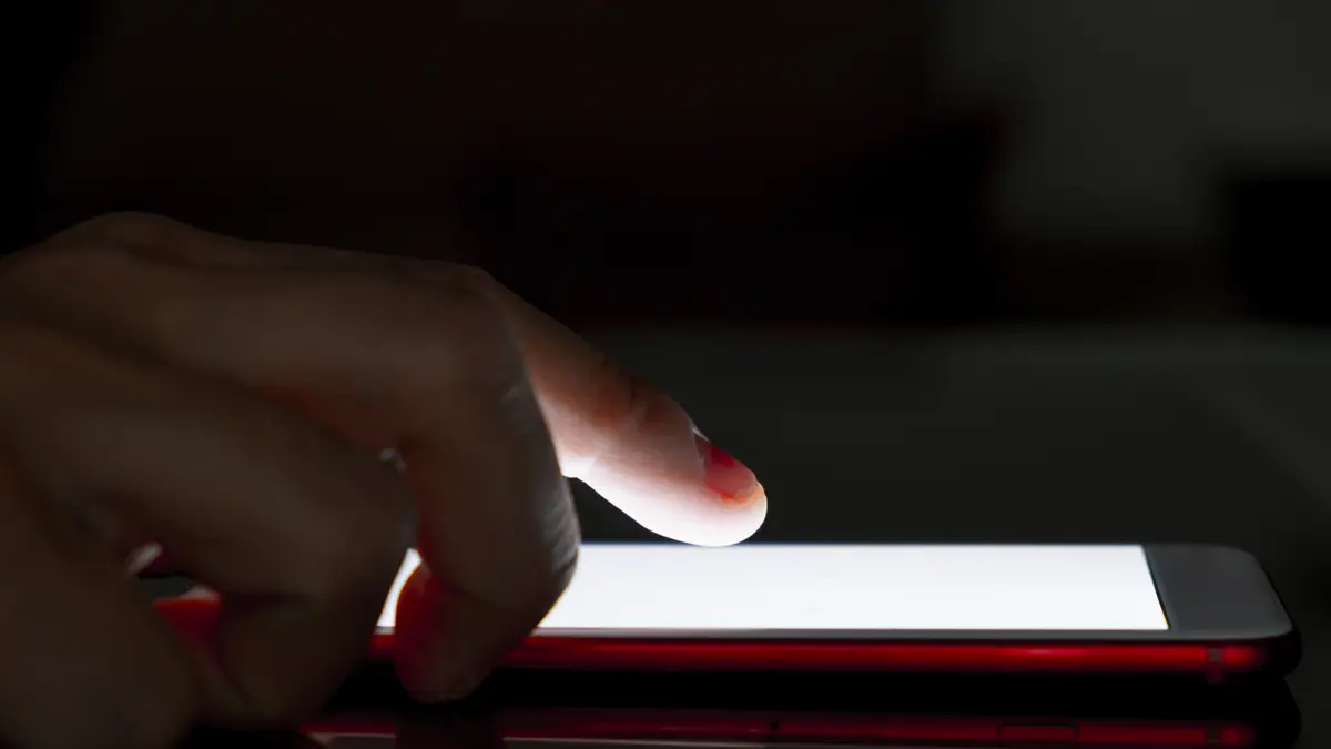 Closeup of a man using his smartphone at night