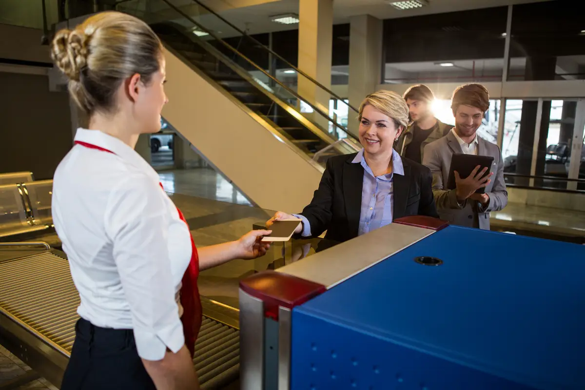 Businesswoman in queue receiving passport and boarding pass