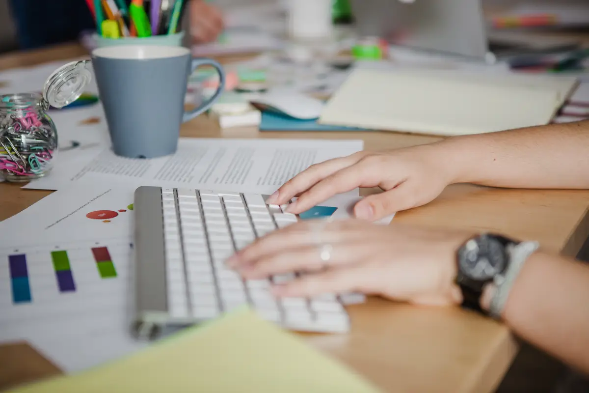 Hands of woman typing in office