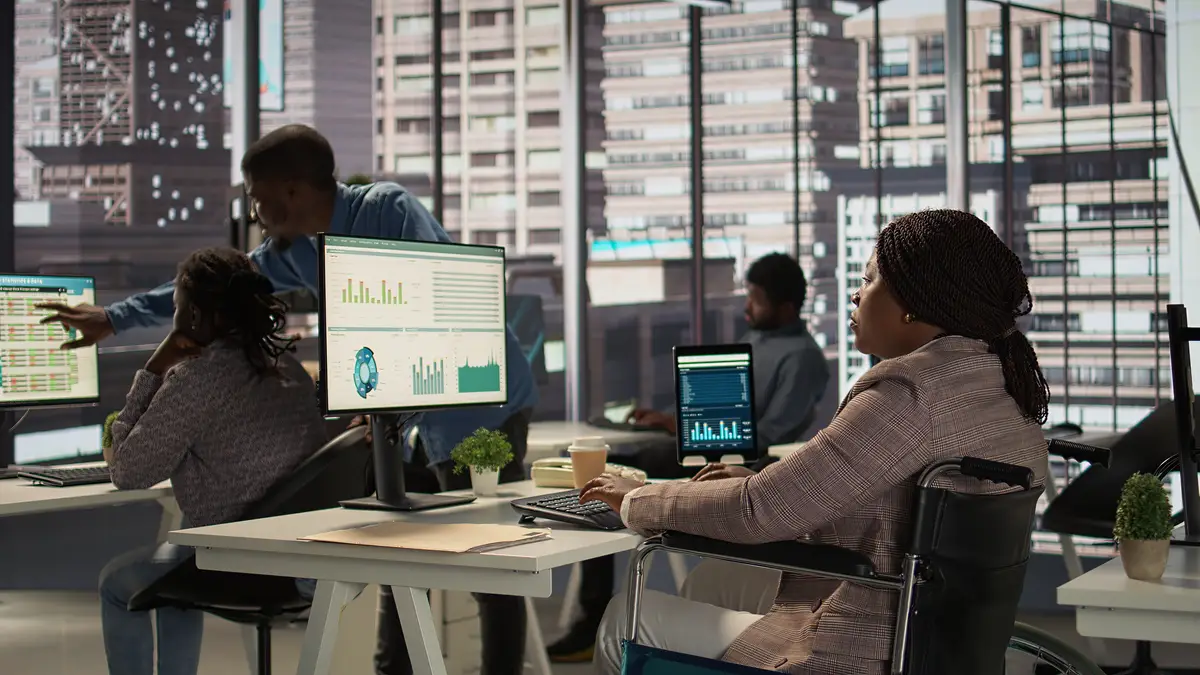 Black manager wheelchair user reviewing the financial data for monthly reports