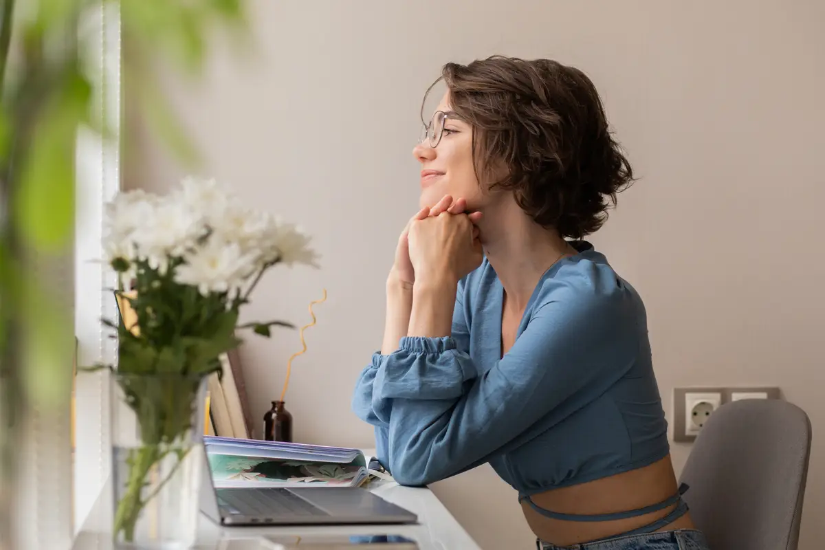 The side view of cute woman sitting at home