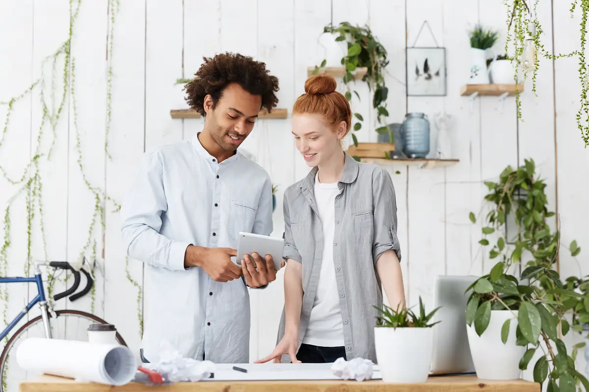Portrait of two creative workers making blueprints together