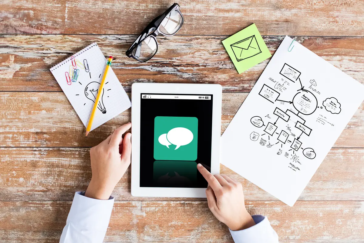 business, education, people and technology concept - close up of female hands pointing finger to tablet pc computer with messenger icon on screen, scheme and eyeglasses