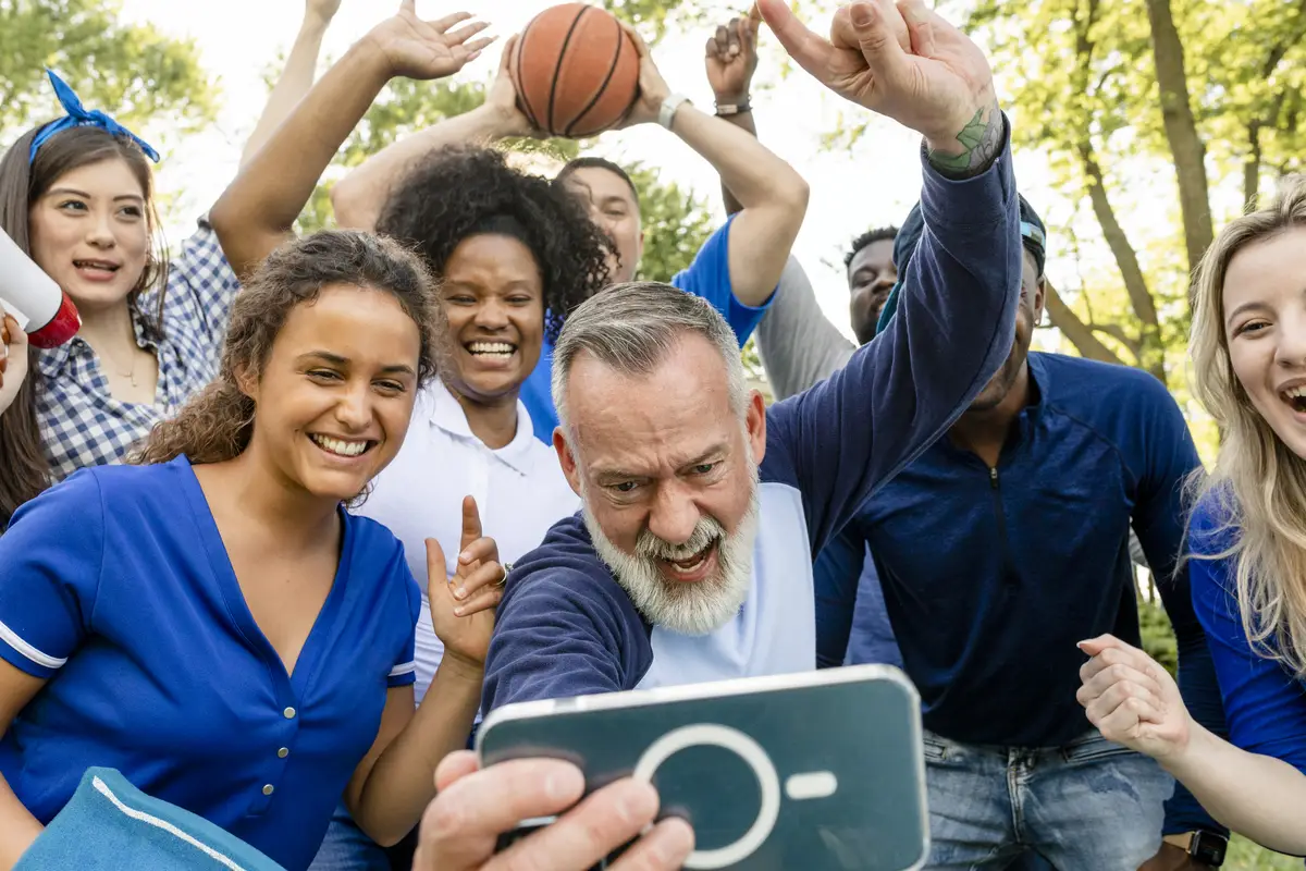 Basketball supporters watching their team win the game on a mobile phone