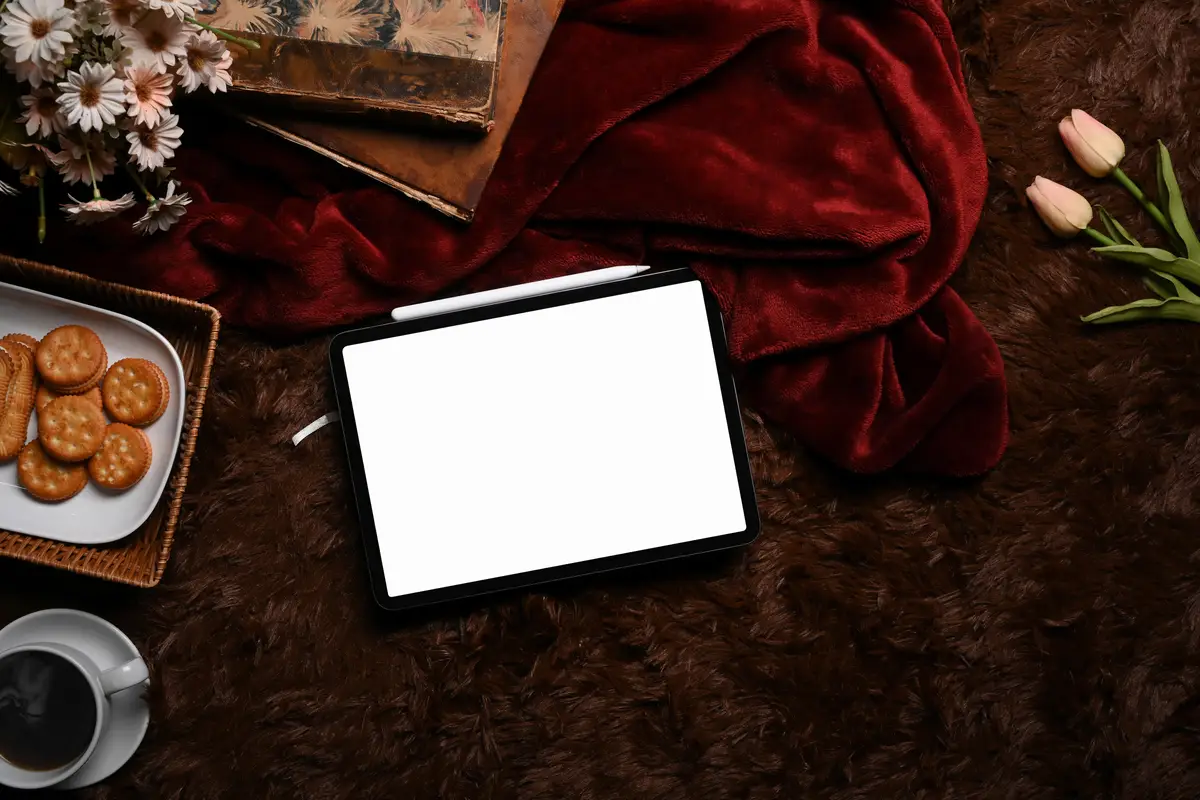 Above view digital tablet cup of coffee cookies and books on fluffy carpet