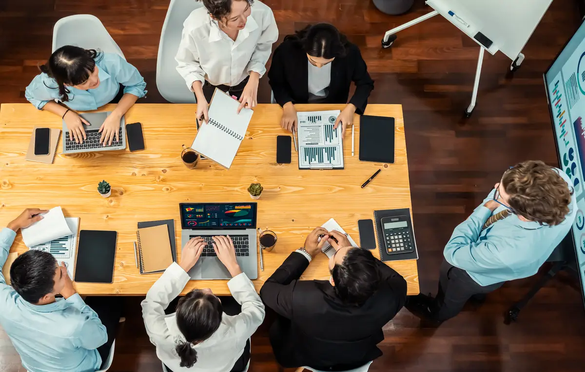Wide top view diverse analyst team analyzing financial data Meticulous