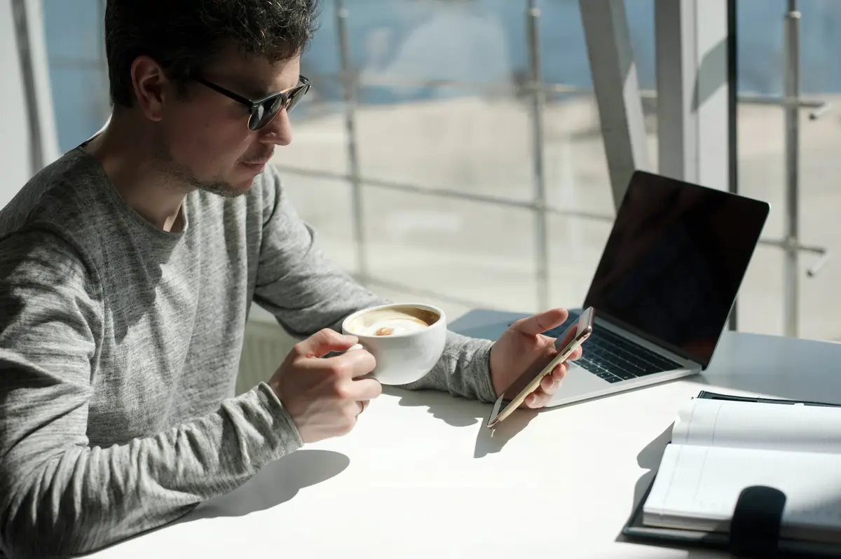 Young woman drinking coffee while sitting on table