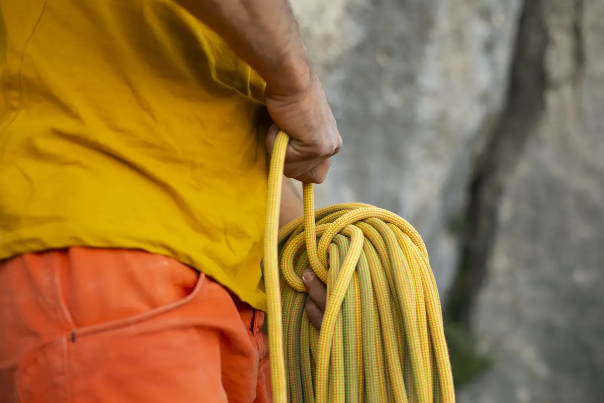 Side view man with climbing  equipment