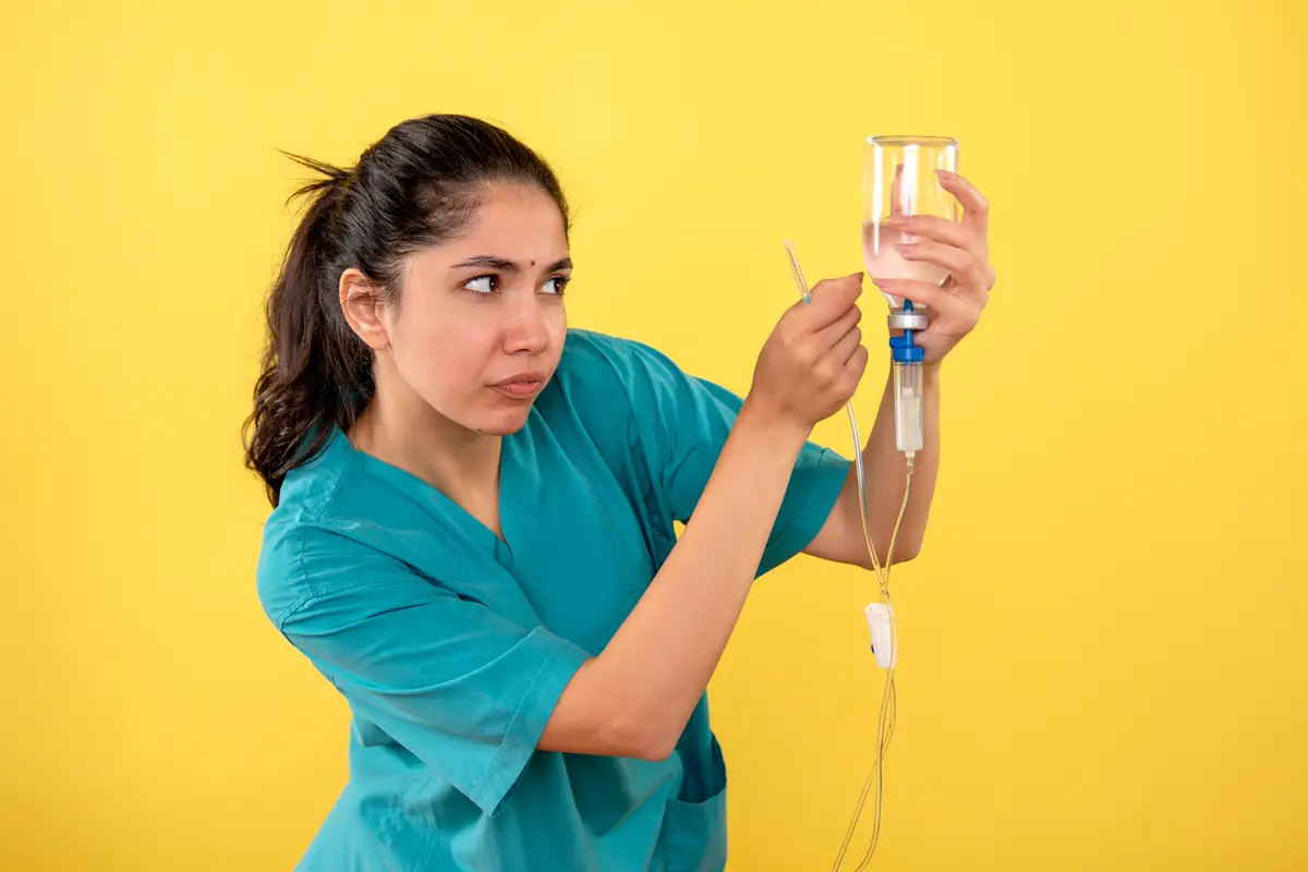 Antibioticoterapia para bacteremia por MSSA: cefazolina ou oxacilina 2 Front view of young female doctor using serum on yellow wall