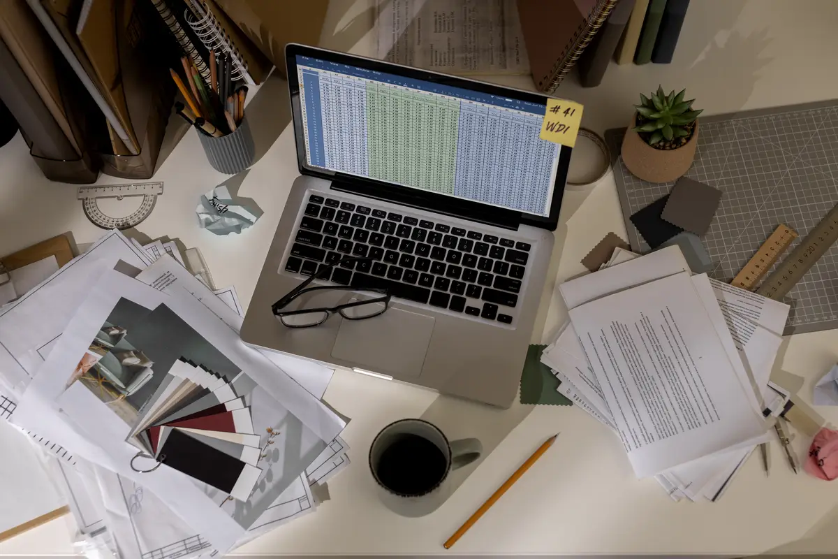 View of messy office workspace with laptop device
