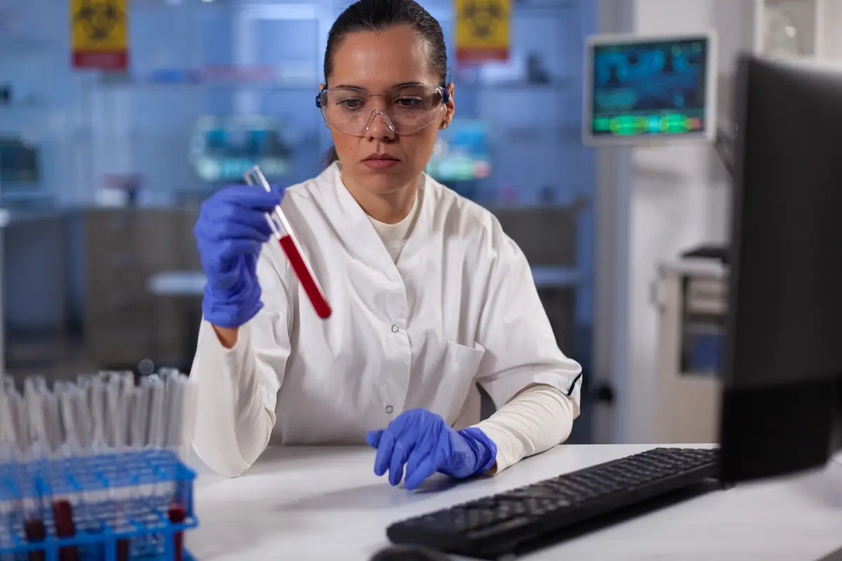 Latência e diagnóstico da infecção tuberculosa: testes e diferenças 2 Chemist researcher holding test tubes with patient blood working at disease diagnostic in biochemical hospital laboratory. Doctor developing medical vaccine against covid19 during chemistry experiment
