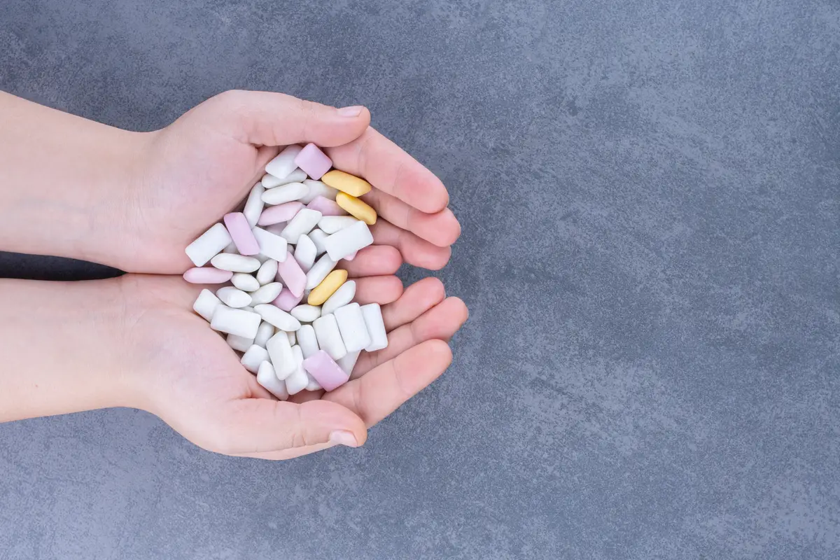 Eficácia e segurança dos regimes de duas drogas no HIV 2 Cupped hands holding a small pile of gum tablets on marble surface