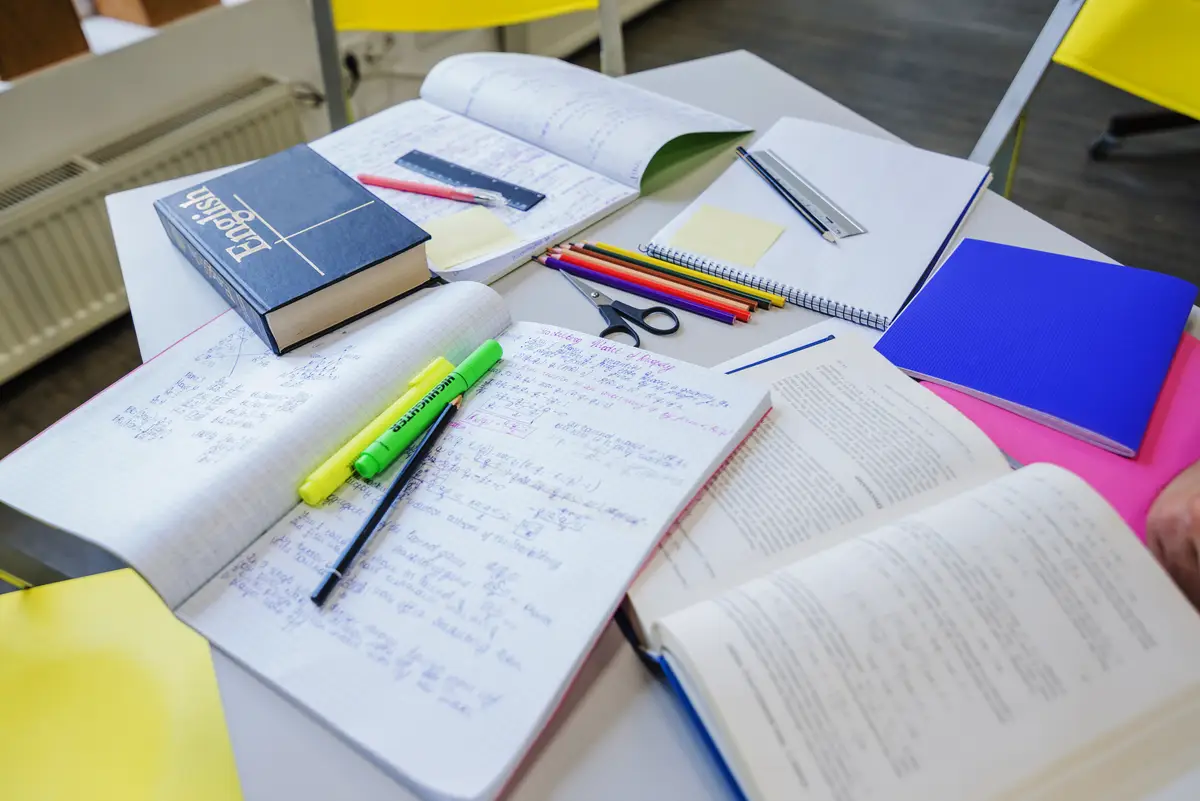 Textbooks and notepads on table