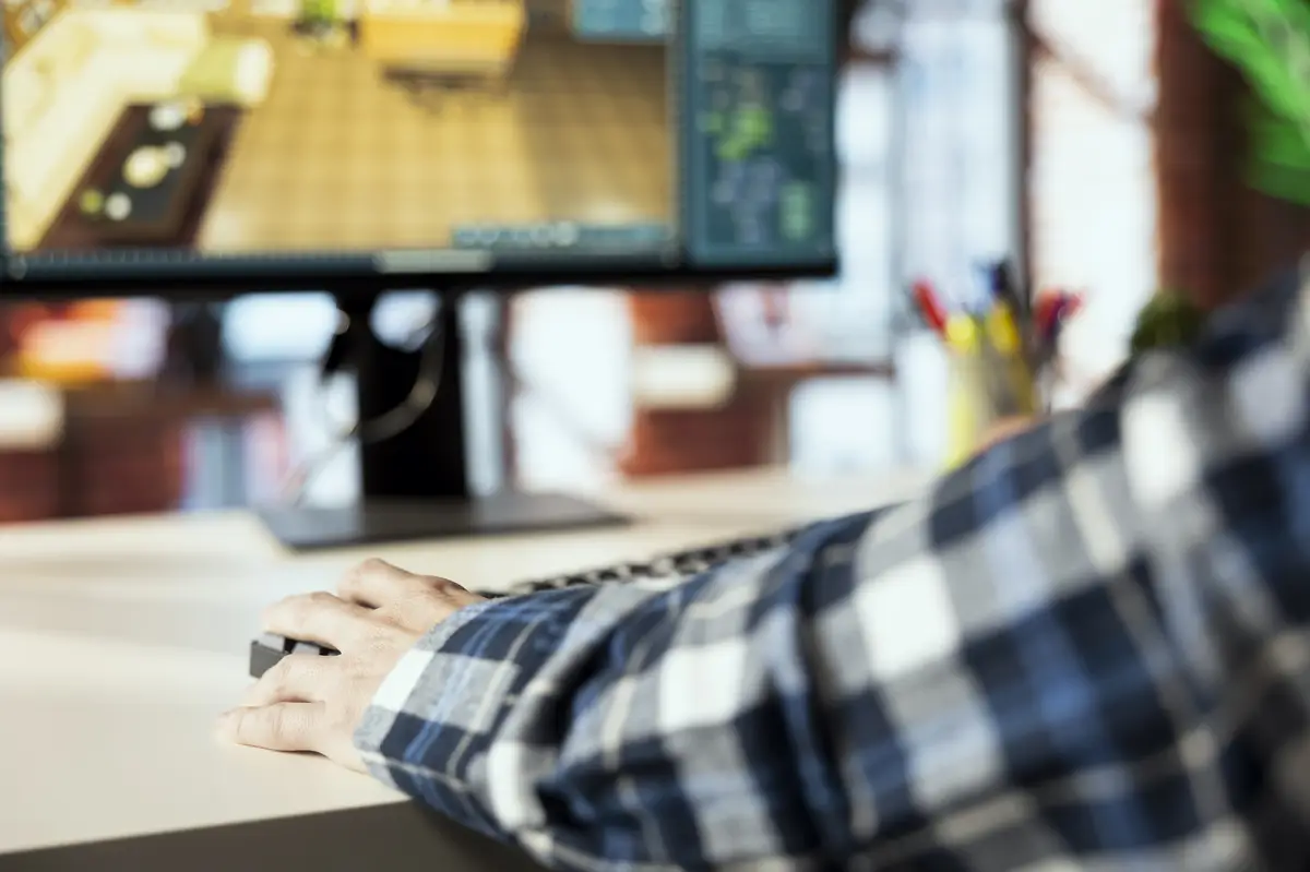 Close up of man in home office using CAD software arranging furniture