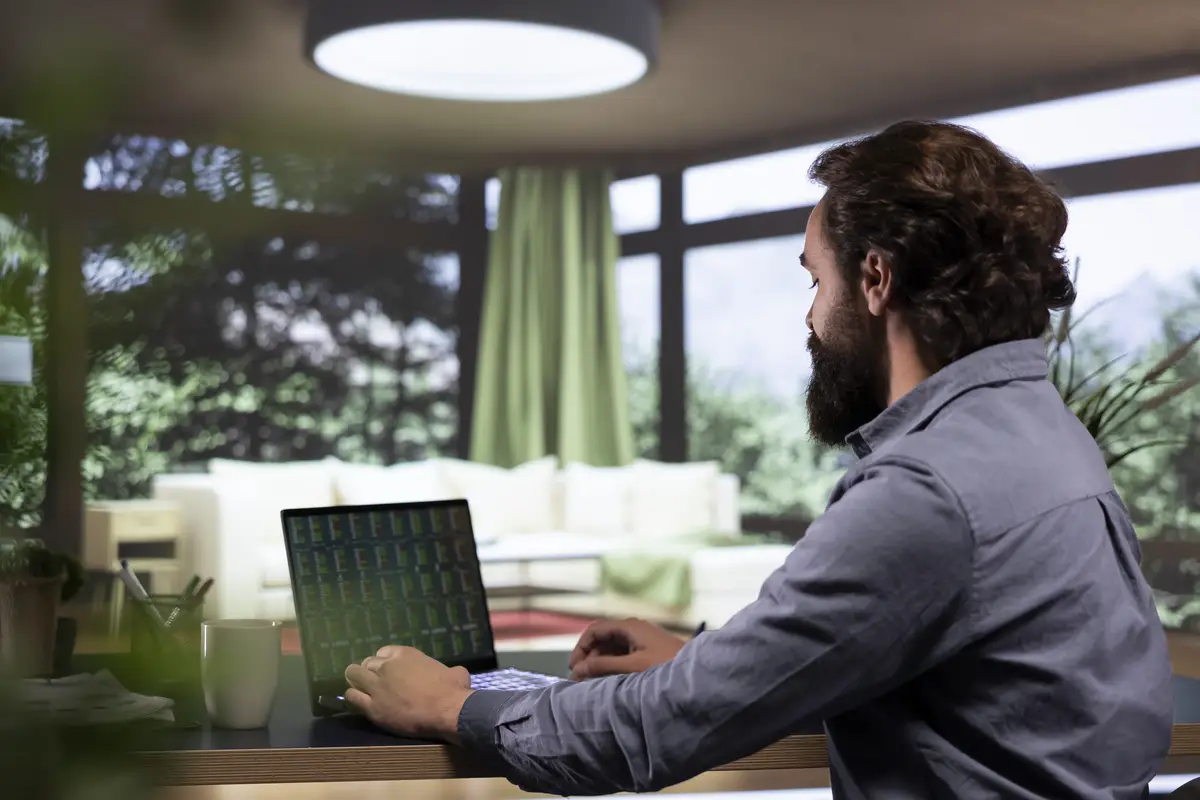 Financial expert opening laptop to review stock trade trends