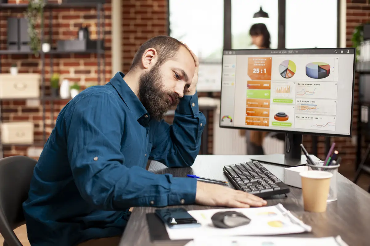 Exhausted businessman holds his forehead