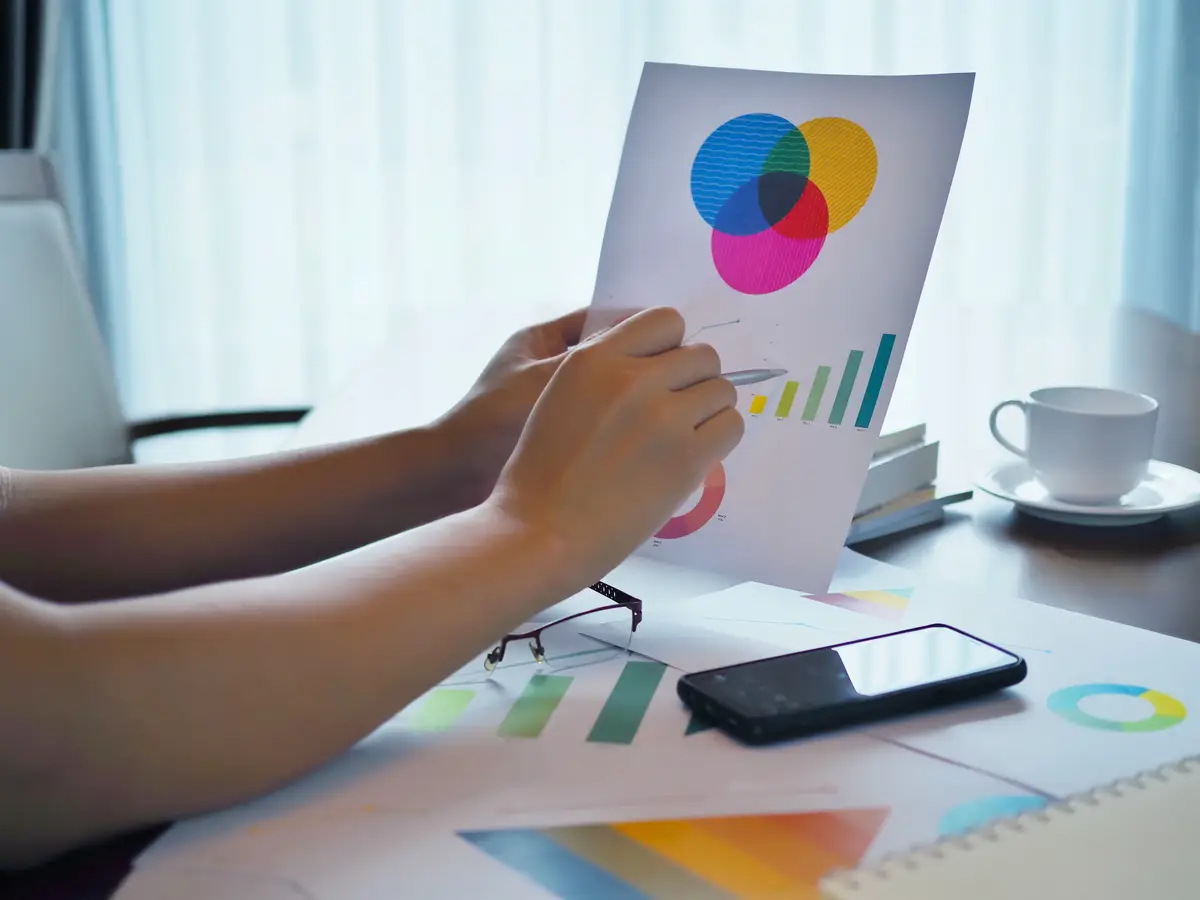 Cropped hand of business person working over graph in office