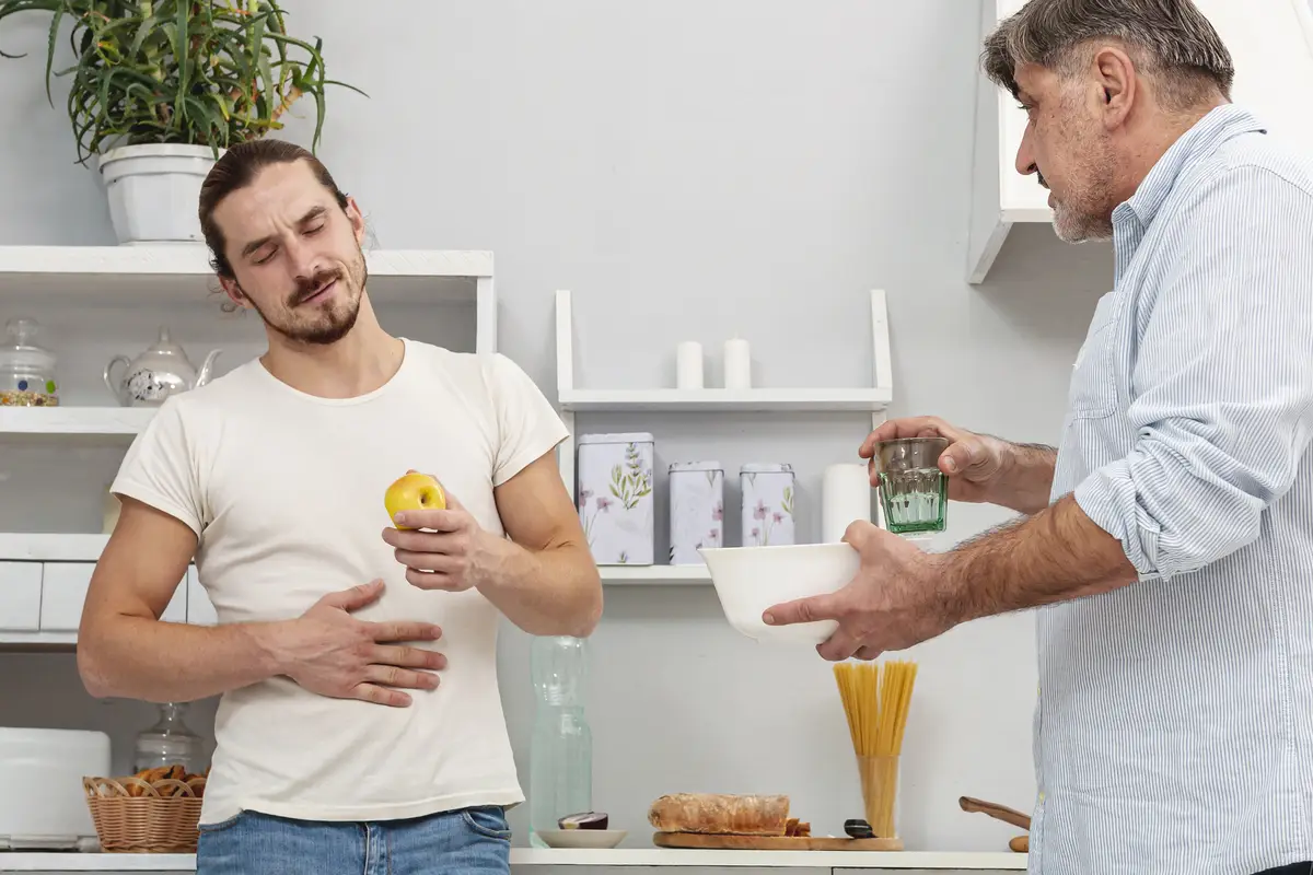 Father offering son a glass of water and a bowl