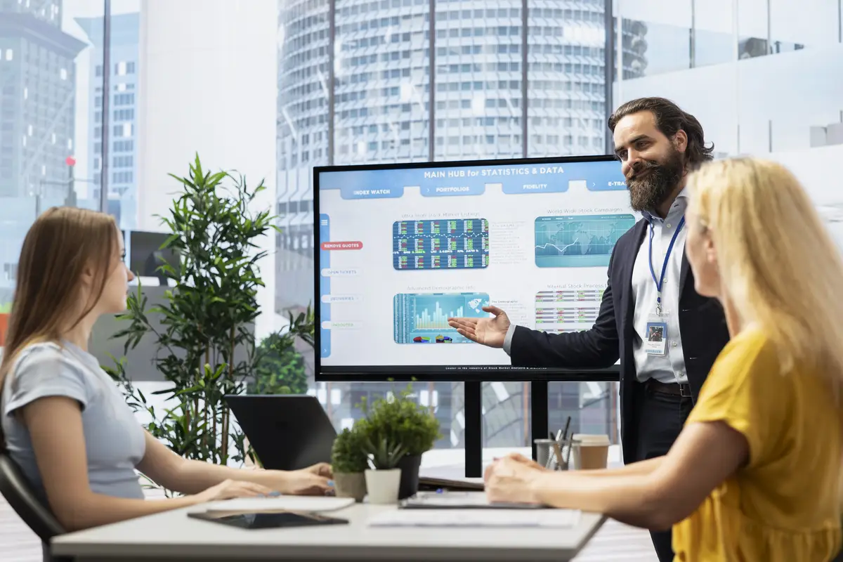 Broker showing trading economic analytics figures on big screen to clients