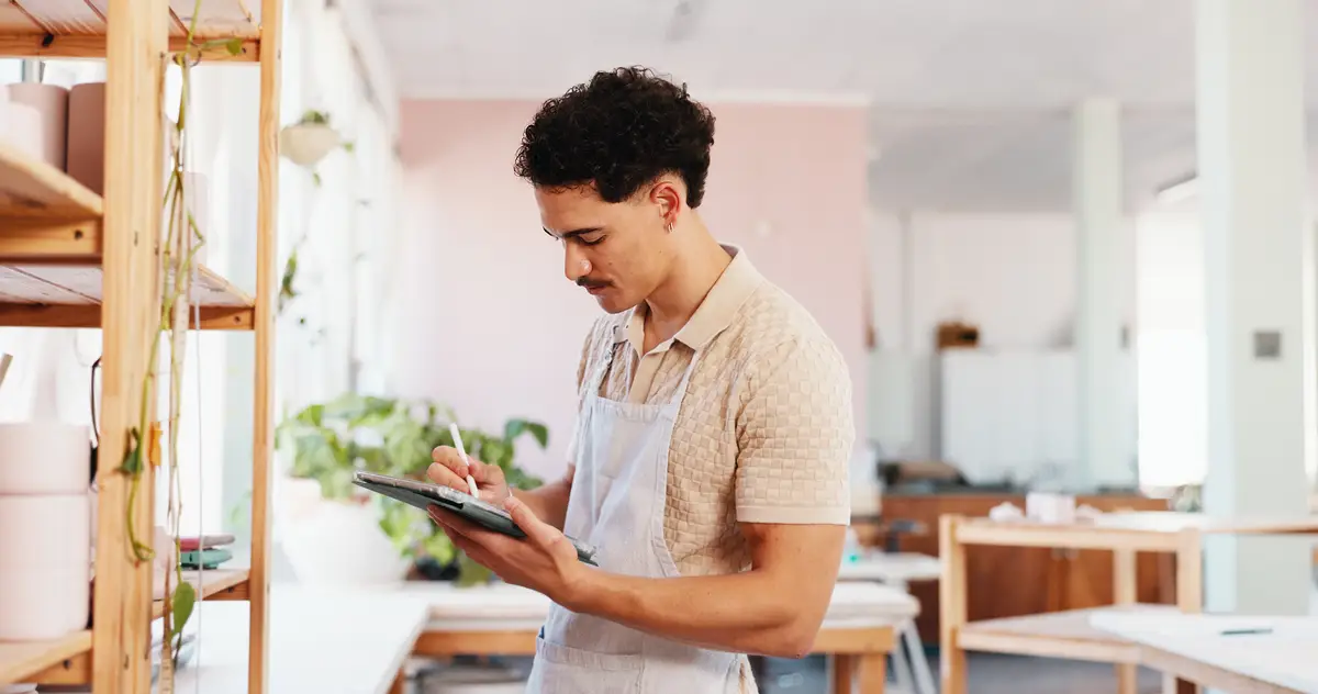 Ceramic pottery and man with tablet in studio for inventory management product inspection and quality control Startup potter and digital checklist for stock supply and pricing invoice at shelf