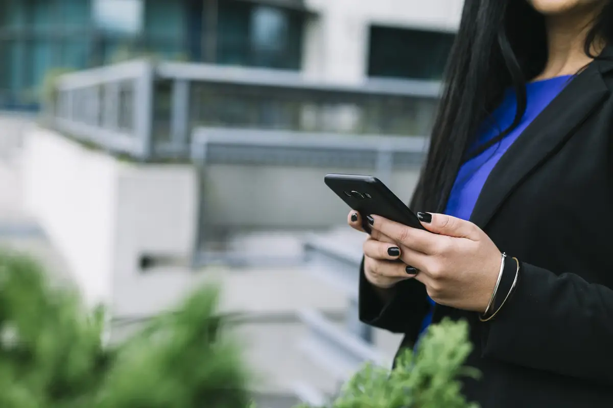 Close-up of a businesswoman's hand using cellphone