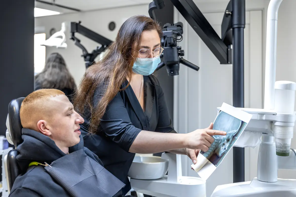 Young female dentist showing a patient a dental xray dentistry concept