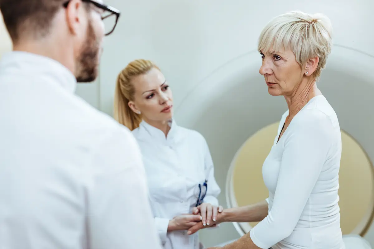 Serious senior woman communicating with radiologist before undergoing on CT scan procedure in the hospital