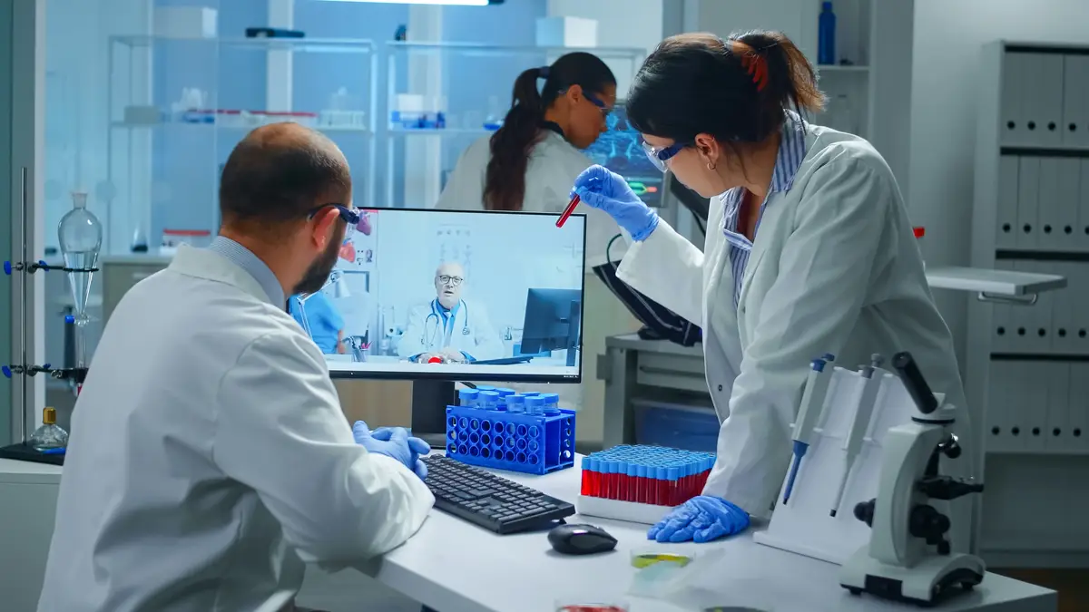 Manejo da bacteremia estafilocócica persistente e do controle de foco 2 Lab technicians talking on video call with professional chemist doctor explaning vaccine reactions