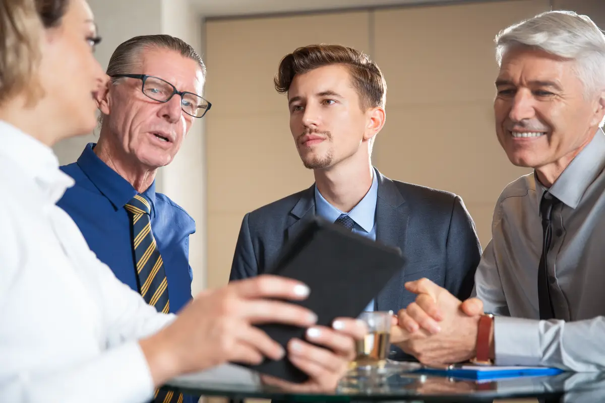 Four Business People Using Tablet in Cafe