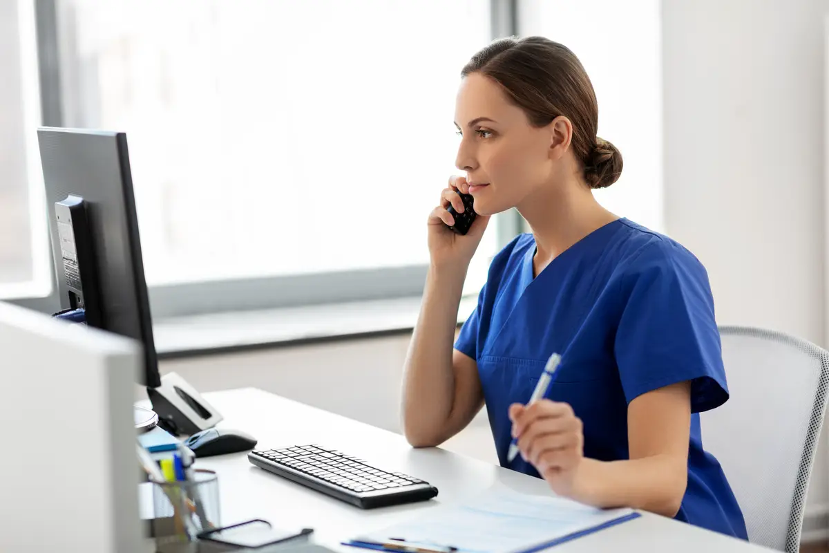 doctor with computer calling on phone at hospital