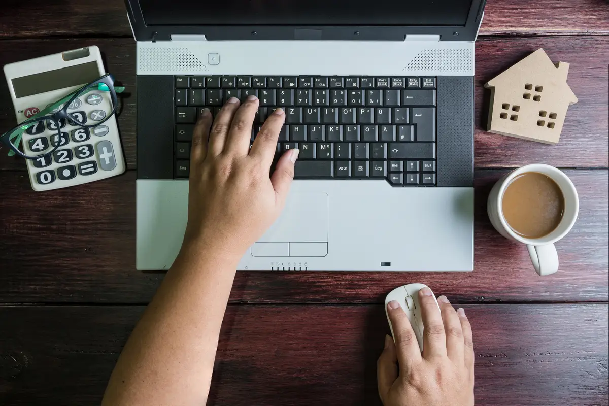 Cropped hands of person using laptop on table